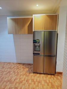 a kitchen with a stainless steel refrigerator in a room at Tastefully furnished 4bedrooms Guzape with pool in Abuja