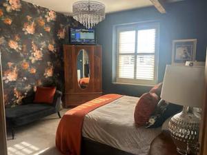 a bedroom with a bed and a chair and a mirror at Westfield House in Gargrave