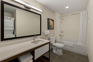 a white bathroom with a sink and a toilet at Everhome Suites Somerset - South Brunswick in Somerset +23 photos