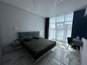a bedroom with a bed and a large window at Елегія парк in Odesa