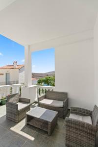 a patio with wicker chairs and a table with a view at Chora Sea Nest, 2-BDR Flat in Andros Town in Andros