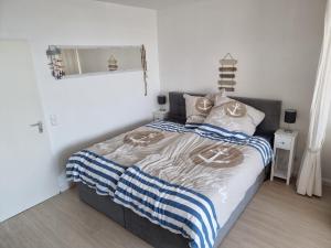 a bedroom with a bed with a blue and white blanket at Wohnung Südstrand Glück in Fehmarn