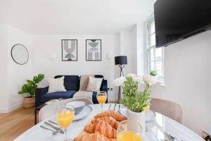 a living room with a table with glasses of orange juice at BnBNova - Soho & Fitzrovia with Balcony in London +15 photos