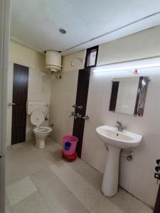 a bathroom with a toilet and a sink at Hotel Sandhyana Inn in Dharamshala