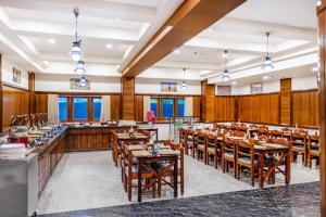 a restaurant with wooden walls and tables and chairs at Sterling Darshan Guruvayur in Guruvāyūr