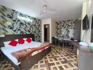 1 dormitorio con cama con almohadas rojas y escritorio en Hotel Sandhyana Inn Peaceful stays near Bhagsu Waterfall, en McLeod Ganj 35 fotos más
