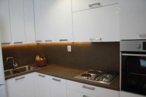a kitchen with a stove top oven next to a sink at Apartman Kristina, studio i soba in Primošten