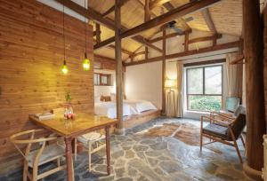 Un dormitorio con una cama y una mesa y sillas. en Xipo Moganshan Resort Homestay, en Houhong