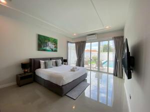 a bedroom with a bed and a sliding glass door at Modern Villa 3BR - Great Location - KL3 in Hua Hin