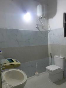 a bathroom with a toilet and a sink and a light at Lakshmi Villa in Aluthgama +18 photos