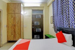 a bedroom with a bed with a red pillow and a window at Hotel O Wamson Alpha Co living Stays in Noida