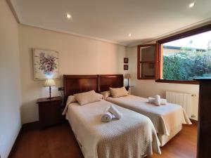 a bedroom with two beds and a window at Apartamentos Mazuga Rural in Po +95 photos