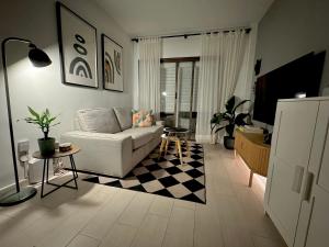 sala de estar con sofá y suelo a cuadros en Calle Real Apartment, en Arrecife