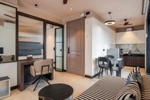 a living room with a couch and a kitchen at Micasa Suites in New Delhi
