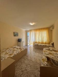 a hotel room with two beds and a window at Guest Rooms Nia Elis Kiten in Burgas City