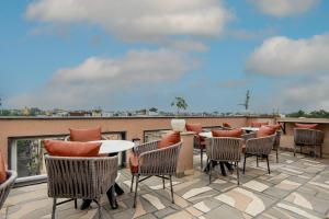 a patio with tables and chairs on a roof at Micasa Suites in New Delhi