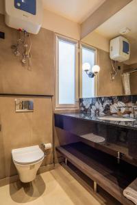 a bathroom with a toilet and a sink at Micasa Suites in New Delhi +10 photos