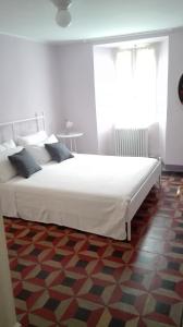 a large white bed in a room with a window at Residenza Se son Rose in Schignano