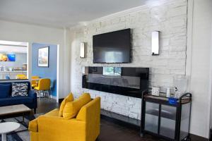 - un salon avec un canapé jaune et une cheminée dans l'établissement Comfort Inn & Suites Coralville - Iowa City near Iowa River Landing, à Coralville
