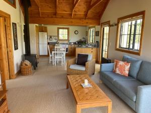 a living room with a couch and a table at Dara Vineyard Cottage in Martinborough