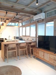 a kitchen with a large kitchen island and a tv at Villa Lumbung Uluwatu 2 in Uluwatu