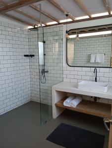 a bathroom with a sink and a glass shower at Villa Lumbung Uluwatu 2 in Uluwatu