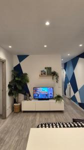 ein Wohnzimmer mit blauen und weißen Wänden und einem Fernseher in der Unterkunft Appartamento in centro storico in Sanremo