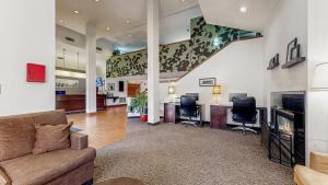 a living room with a couch and two chairs at Sleep Inn & Suites Buffalo Airport in Cheektowaga