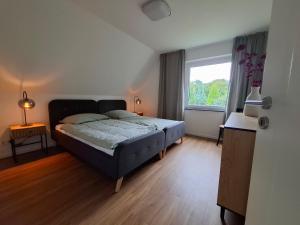 a bedroom with a bed and a large window at Bright 3-room apartment - space for family & friends in Tecklenburg +6 photos