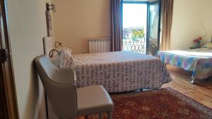 Cette chambre comprend un lit, une chaise et une fenêtre. dans l'établissement Boomerang Cottage B&B - Quintanapalla, à Quintanapalla