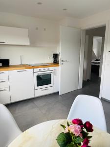 Una cocina con una mesa con un jarrón de flores encima. en Ankommen, Wohlfühlen! - FeWo Schömberg, en Schömberg 11 fotos más