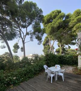 un tavolo e sedie su una terrazza in legno con alberi di Villa CASTILLA a Cambrils
