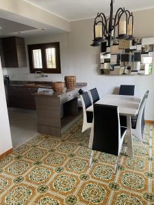 una cucina e una sala da pranzo con tavolo e sedie di Villa CASTILLA a Cambrils