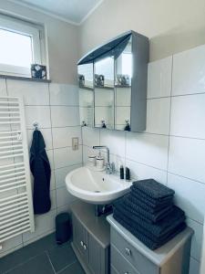 a bathroom with a sink and a mirror at Preiswerte Wohnung nahe Düsseldorf inklusive Stellplatz in Haan