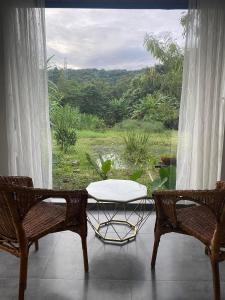 a table and two chairs in front of a window at Hannah Garden in Buôn Kdŭn