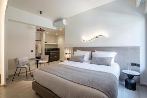 a bedroom with a large bed and a kitchen at Zoera Suites by Ethos in Chania Town