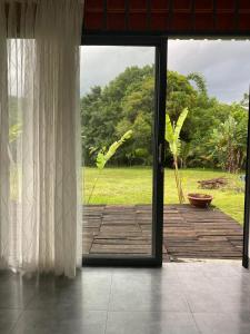 an open door to a patio with a view of a field at Hannah Garden in Buôn Kdŭn