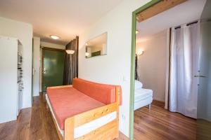 a room with a orange bench in a room at Appartement 'Bds1 37' 5 Couchage in Saint-François-Longchamp