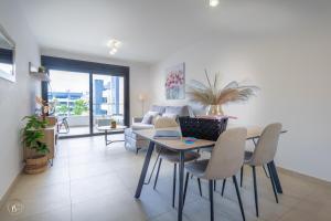 a living room with a table and chairs and a couch at NEW - Flamenca Village - fantastic location! in Orihuela