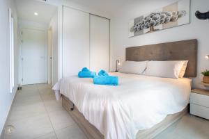 a bedroom with a large bed with blue towels on it at NEW - Flamenca Village - fantastic location! in Orihuela +22 photos