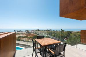 Una mesa y sillas en un balcón con vista al mar. en Adhara 053, en Torre del Mar