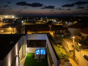 a view of a city at night from a building at Olga Resort - אולגה ריזורט in H̱adera +68 photos