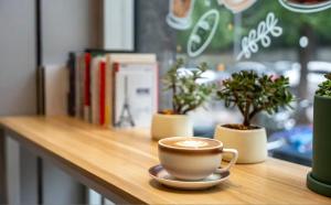 成都市にあるQingju Hotel, Chunxi Road, Taikoo Li, Chengduの植物のあるテーブルに座ってコーヒーを飲む
