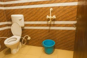 a bathroom with a toilet and a blue bucket at Shri Mukund Dham - Near Prem Mandir, Iskcon temple & Banke Bihari G- Premanand Maharaj Visit is just 2-3 minutes away in Mathura +9 photos