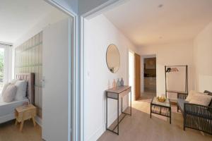 a living room with a bed and a mirror at Appartement familial confortable in Issy-les-Moulineaux