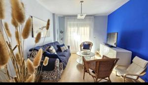 Sala de estar azul con sofá y mesa en Atardeceres en Bajoguía, en Sanlúcar de Barrameda