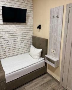 a room with a bed and a tv on a brick wall at Coffee Room in Odesa