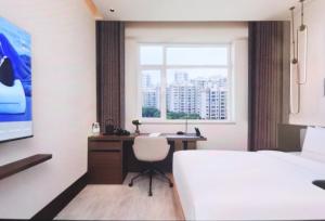 Atour Hotel Hohhot Wanda Plaza, Xinhua Street في هوهوت: غرفة نوم مع مكتب وسرير ونافذة