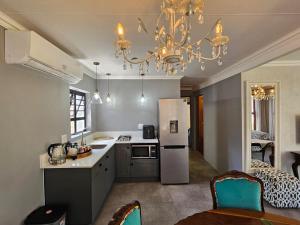 a kitchen with a refrigerator and a table with chairs at Villa Petit in Jeffreys Bay
