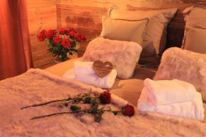 a bed with towels and a bouquet of red roses at Charmante escapade in Baccarat